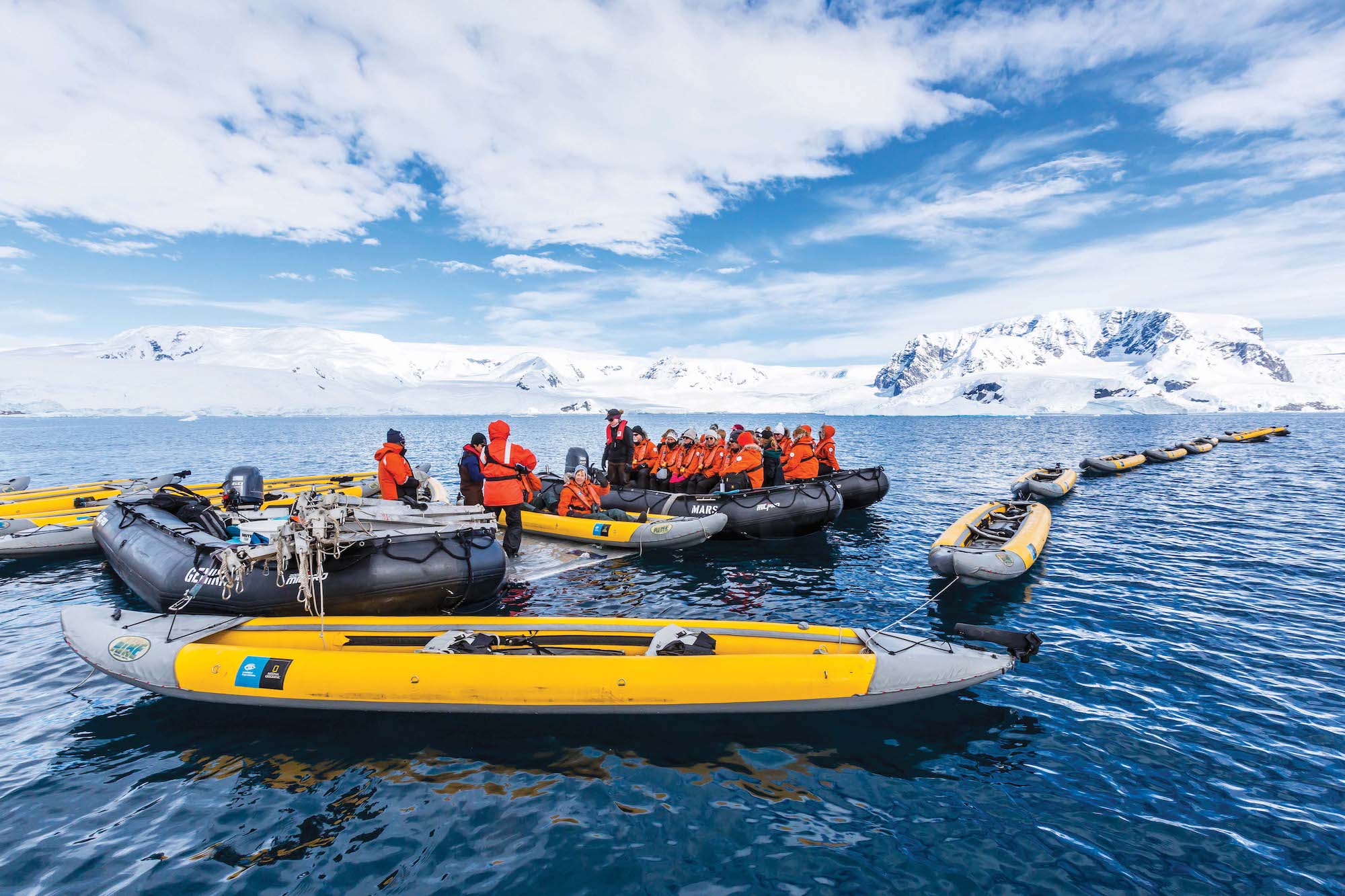 Guests on a Lindblad expedition wait to board kayaks in the polar region